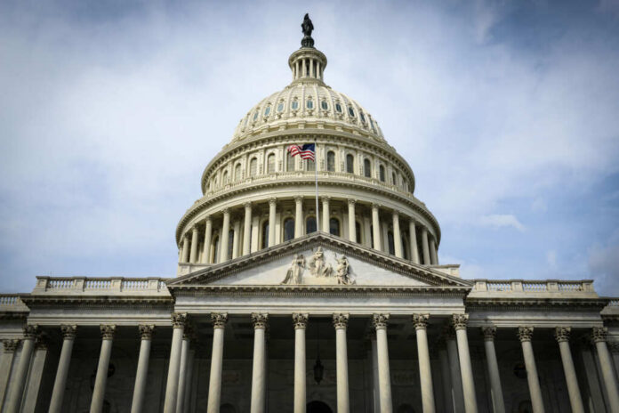 shutterstock_179079596.jpg The U.S. Capitol building with an American flag flying in front