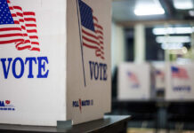 Ultra-Wealthy Dominate 2026 Midterms – What’s Next? Voting booths with American flags in a polling station