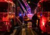Firefighters and fire trucks at a nighttime emergency scene