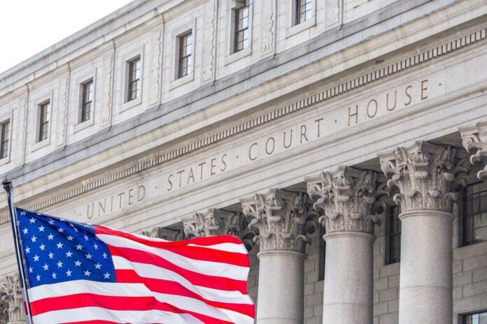 Usa,National,Flag,Waving,In,The,Wind,In,Front,Of Facade of a United States courthouse with an American flag in the foreground