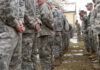 A line of soldiers in military uniforms standing outdoors in formation