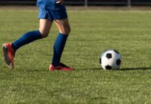 Youth soccer player dribbling a ball on a field