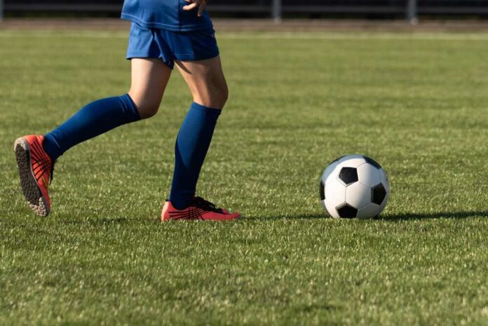 Youth soccer player dribbling a ball on a field