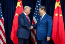 Trump Leads CEOs to Beijing – BILLIONS at Stake! Two political leaders shaking hands in front of national flags
