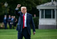 Massive Wins: Trump Allies Reshape GOP Landscape A political figure walking outdoors with a raised fist