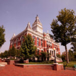 Courthouse SHOOTING Stuns Tennessee—Streamer Jailed! Historic red-brick courthouse with clock tower and trees in a sunny plaza