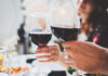 California Winery Faces MAGA Trademark Assault Two people toasting with glasses of red wine at a dining table