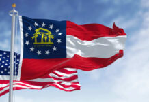 Trump Endorsement Crumbles — Money Wins Georgia state flag and American flag waving against a blue sky