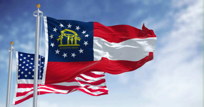 shutterstock2144966627jpg-1 Georgia state flag and American flag waving against a blue sky