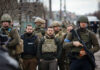 Bipartisan Rebellion Upends Ukraine Cash Push A group of military personnel in tactical gear walking through an urban area