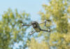 Russia Plot Alleged, Receipts Missing A drone flying against a backdrop of green trees and a blue sky