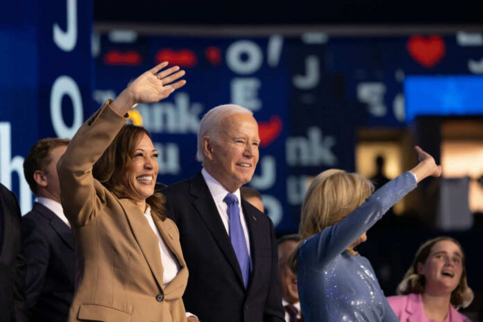 Group of political figures waving at an event, smiling and engaging with the audience