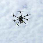 A drone flying against a cloudy sky