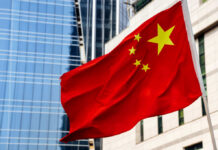 Chinese Cloud Giants Branded Military Risk Chinese flag waving in front of modern buildings