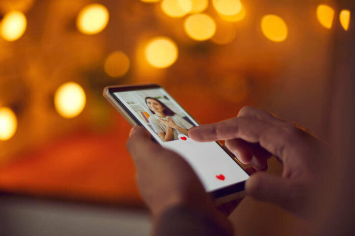 Find,Love,Online,Concept.,Man,Holding,Mobile,Phone,,Looking,At Person using a smartphone to interact with a dating app