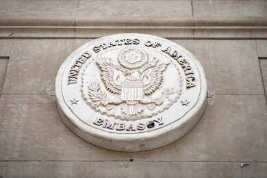 shutterstock_1936207963 Seal of the United States Embassy displayed on a wall