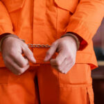 Grammy Rapper Stuns Judge: “Give Me Max” A person in an orange jumpsuit with handcuffs