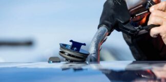 Close-up of a person refueling a vehicle at a gas station