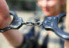 Pride Founder Arrest Rocks Community Close-up of handcuffs being held by a person