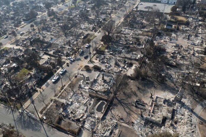A,Drone,Captures,Structures,Damaged,By,The,Eaton,Fire,In Aerial view of a neighborhood devastated by wildfire, showing burned structures and debris