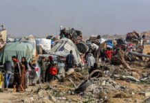 Half Million Civilians Face Sudan Crisis Displaced families with belongings crowd a rubble-strewn road
