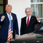 Two political leaders standing outside the White House, one raising a fist and the other waving