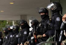 Media Spin Sparks Outrage Over ICE Ambush Police officers in riot gear stand in a line