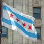 Chicago Bloodshed Sparks Power Clash Chicago flag waving in front of a building