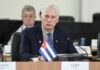 Cuban representative at a political meeting with a flag in front