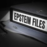 What Is Missing From Epstein Files? A black binder labeled 'Epstein Files' with papers and a pen beside it