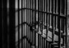 Fake SSNs Flood One Quiet Plant Close-up of prison bars casting shadows on a wall