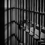 Fake SSNs Flood One Quiet Plant Close-up of prison bars casting shadows on a wall