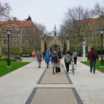 New Florida Rule Reshapes College Access Students walking along a pathway on a university campus with historic buildings in the background