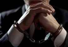 New Details Emerge In NFL Player’s Arrest Businessperson in handcuffs with hands clasped