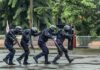 Police tactical team advancing in rain