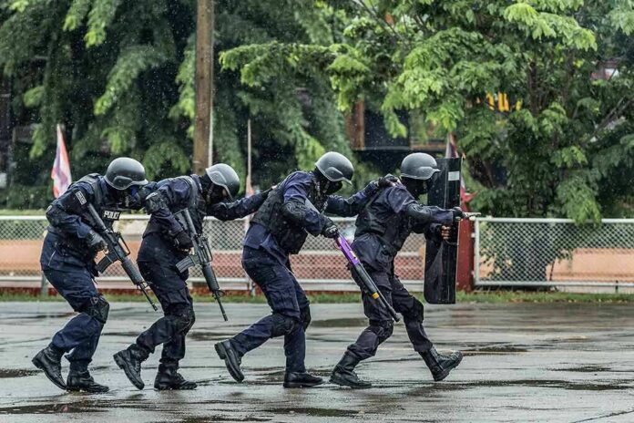 shutterstock_1115325713 Police tactical team advancing in rain