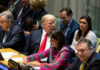 A group of political leaders seated at a United Nations meeting, engaged in discussion