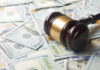 A gavel resting on a pile of hundred dollar bills