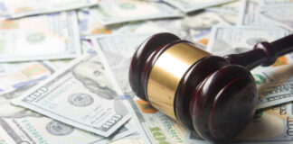 A gavel resting on a pile of hundred dollar bills