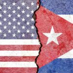 Split wall showing USA and Cuba flags divided by a crack