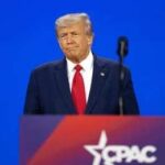 Trump Warns America About Communism A public figure speaking at a podium during a conference