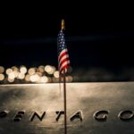 Pentagon Union Purge Sparks Court Showdown A small American flag positioned in front of the word 'PENTAGON' on a reflective surface