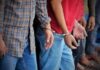 Gang-Rape Numbers Ignite Migration Firestorm Handcuffed people standing in a line