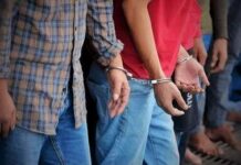 Handcuffed people standing in a line