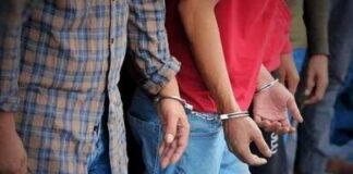 Handcuffed people standing in a line