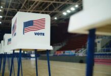 Democrat Quits High-Stakes Senate Race Voting booths with American flags set up in a gymnasium