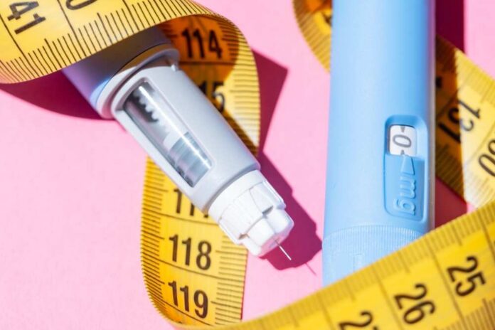 Flat,Lay,Of,Two,Ozempic,Pens,On,A,Pink,Background. An insulin pen and measuring tape on a pink background