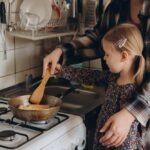 Court Upholds New York Gas Ban Child cooking with adult at a stove