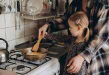 Child cooking with adult at a stove