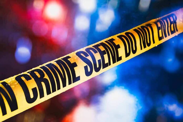 yellow crime scene tape with blurred police lights